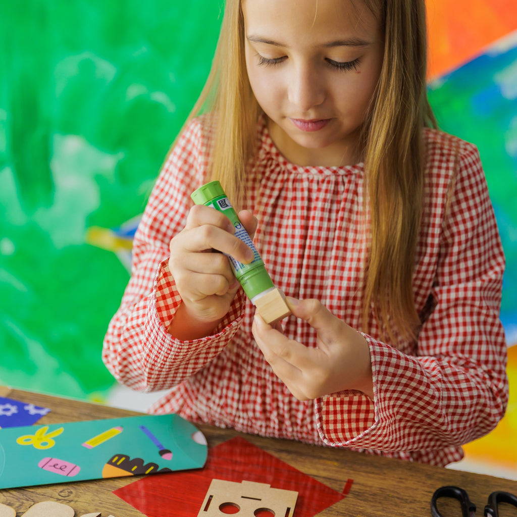 A child attaching wooden block to the wooden robot, learning about basic mechanics and construction.