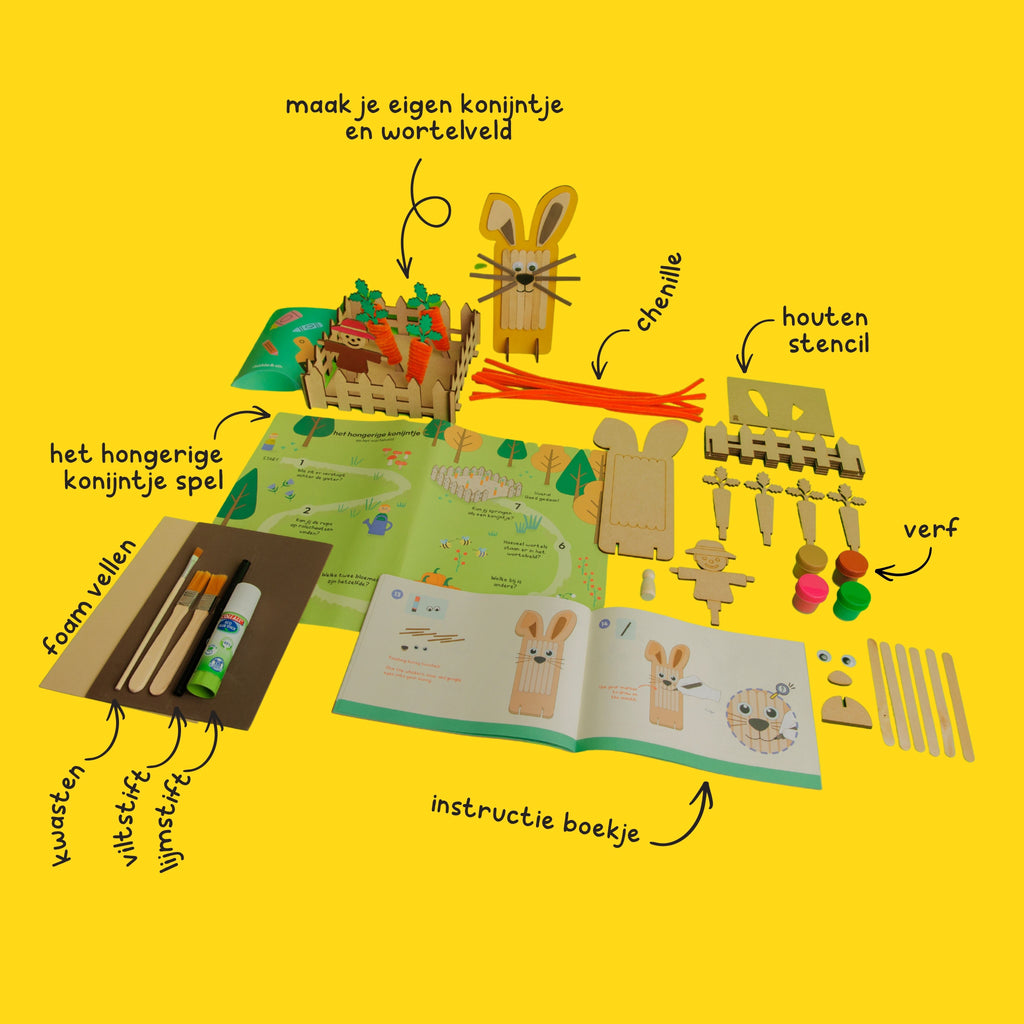 Contents of the Bunny and the Carrot Patch box: including popsicle sticks, foam sheets for ears, wooden carrots, orange pipe cleaners, paint, and an interactive game.