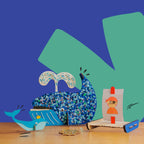 Fiona the Whale craft kit by Dabble & Co. including two wooden whales, a DIY raft with a sail, paint, and glitters.