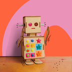 Dabble & Co. Robbie the Robot craft kit: a complete DIY set with a wooden robot, metal spring arms, and a tealight light for glowing eyes.