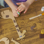 Hands-on crafting: a young maker assembling the Happy Giraffe by attaching textured foam details.