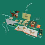 The contents of the Dot the Dog craft box, featuring high-quality wood, sculpting clay for a bone, and colorful textile markers for the bandana.