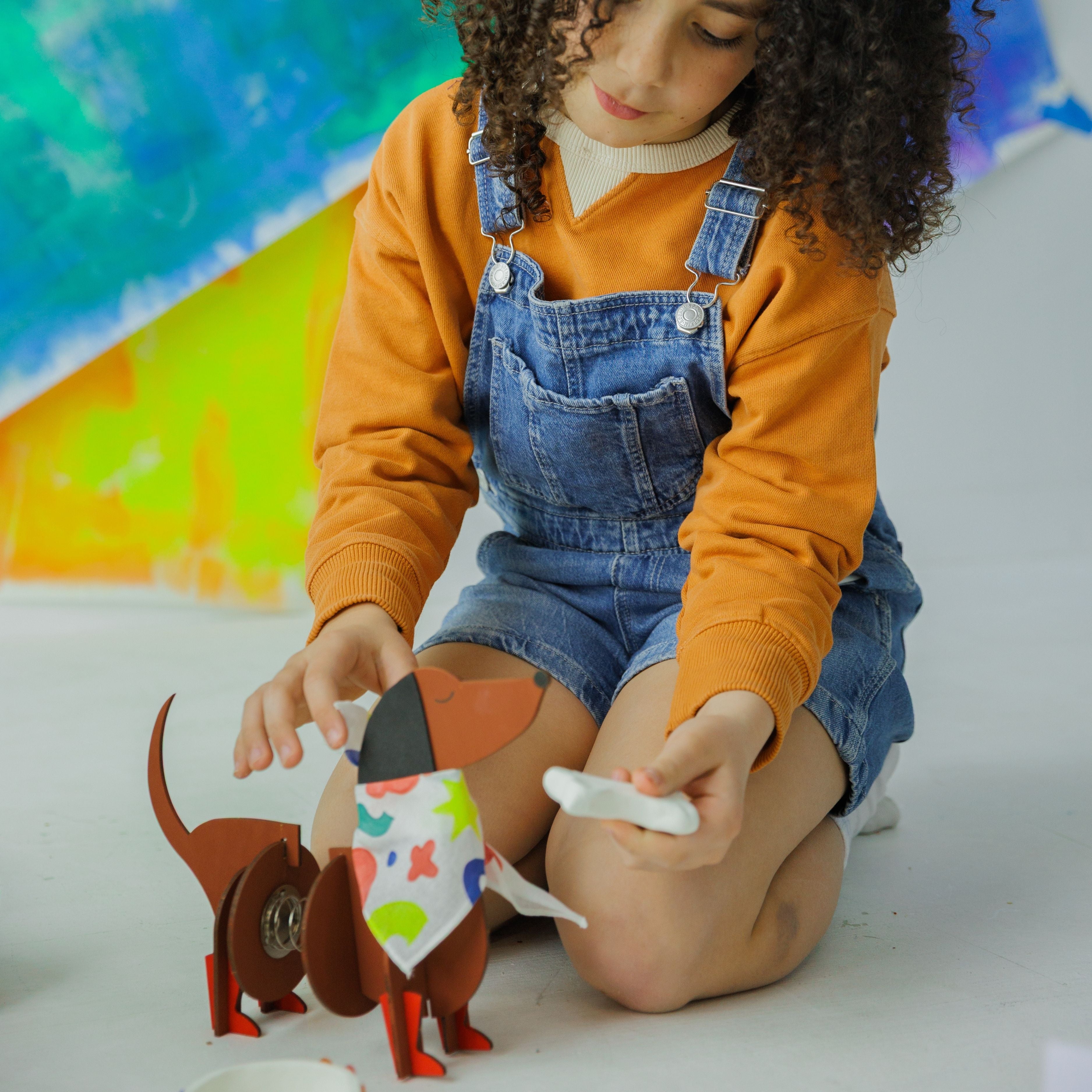A happy child showing off their handmade wooden dog friend, a result of an afternoon of screen-free fun.