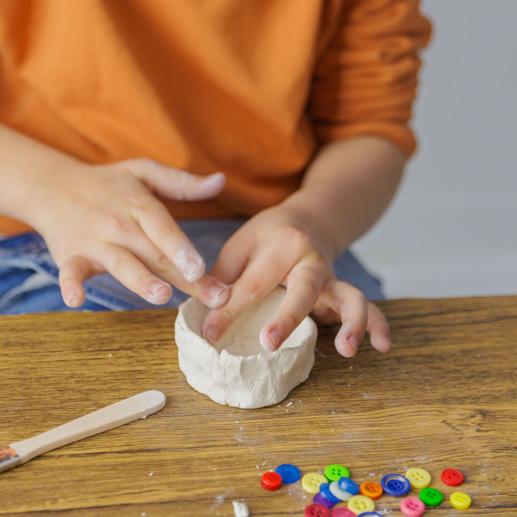 Hand-sculpting a dog bone and a water bowl from air-dry clay, included in the Dabble & Co. set.