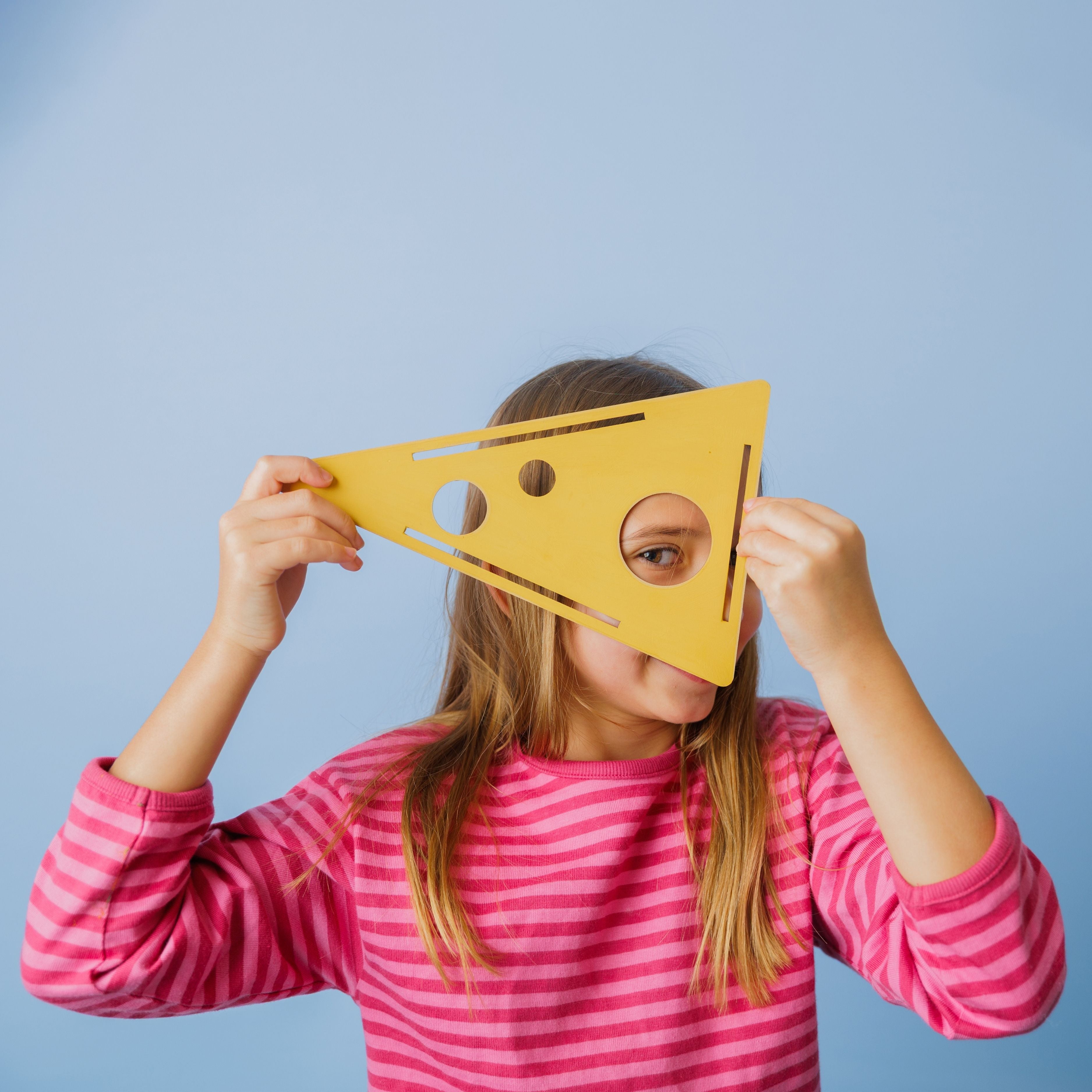 A proud child holding their finished handmade wooden cheese.